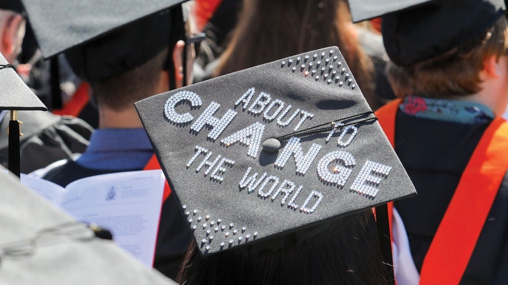Graduation cap with "About to Change the World" printed in white crystals
