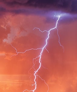 Lightning against a pink and orange sky