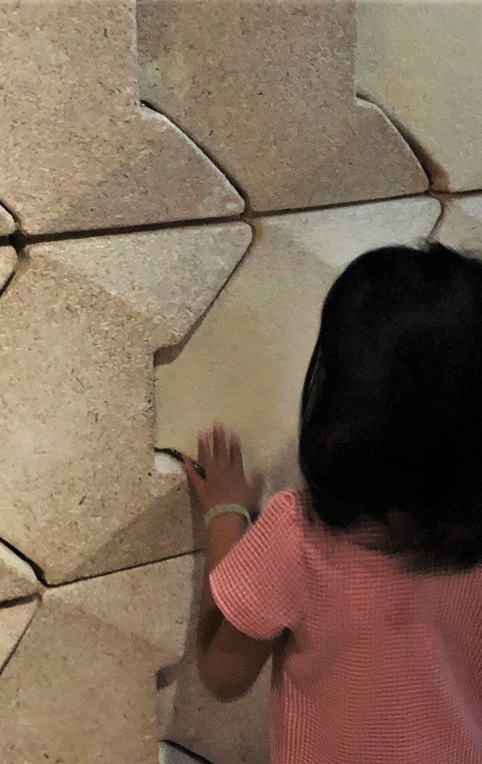 Young girl touching wall 