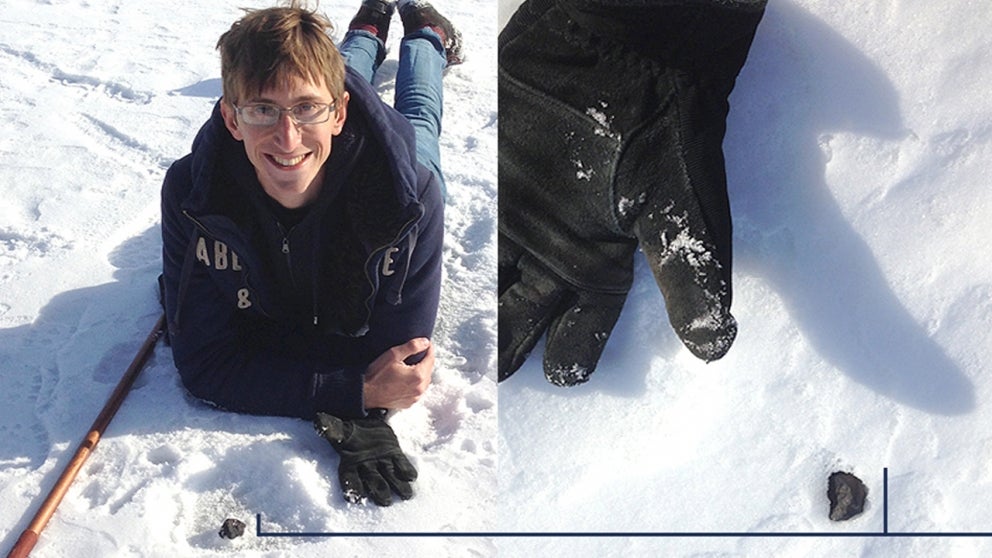 Brandon Weller laying down in snow with meteor discovery