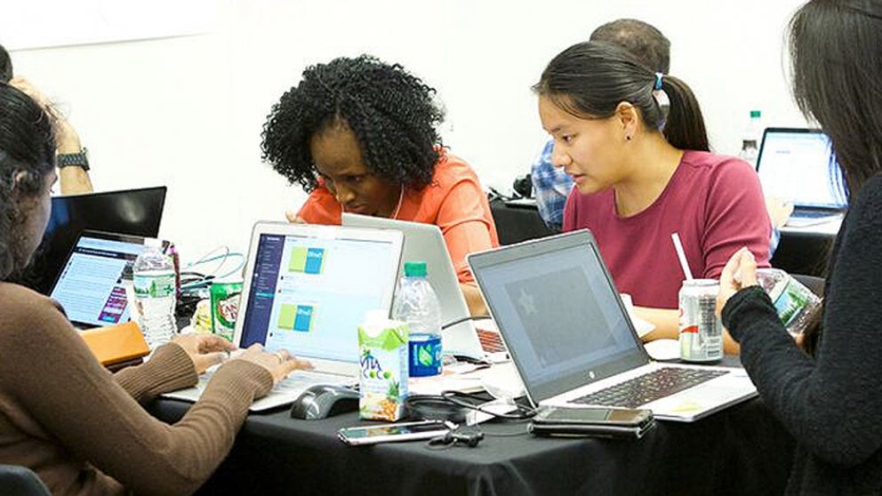 Group of students with laptops participating in the health hackathon