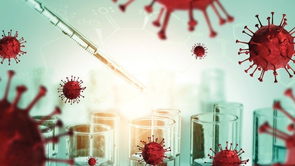 Rendering of the virus that causes COVID-19, with beakers and a pipette in the background.