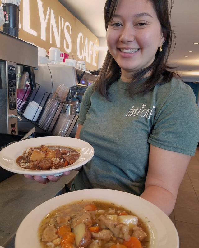 Allison Douglas holding two bowls of organic stew from the Terra Cafe