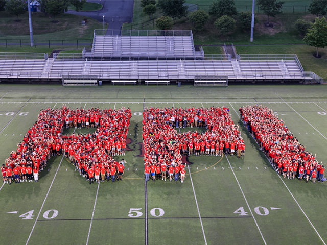 Aerial shot of students wearing red lined up in a way that spells "RPI"