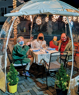People in an outdoor dining igloo